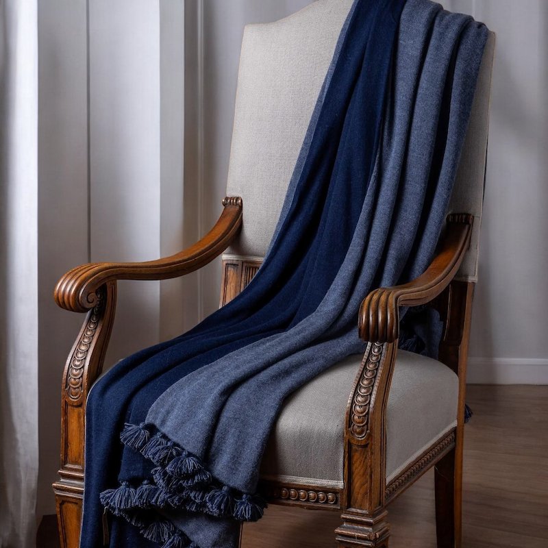 Alicia Adams Alpaca Bali Pompom Throw in Navy and Denim Blue shown on Chair - Fig Linens and Home