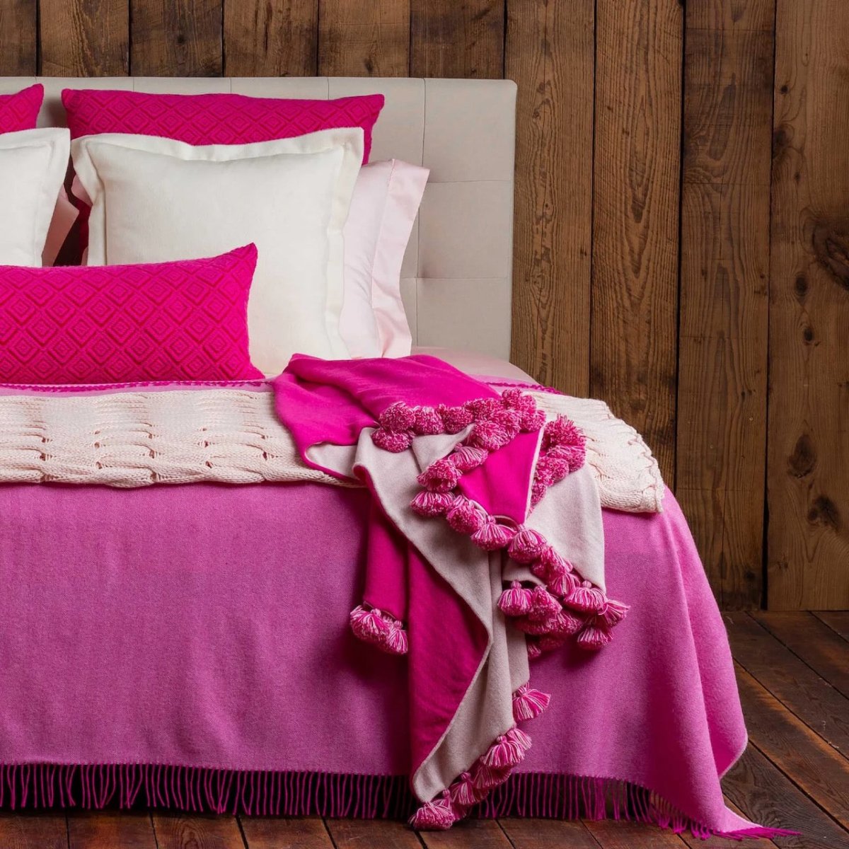 Alicia Adams Alpaca Bali Pompom Throw in Pink Powder and Shocking Pink shown on Bed - Fig Linens and Home
