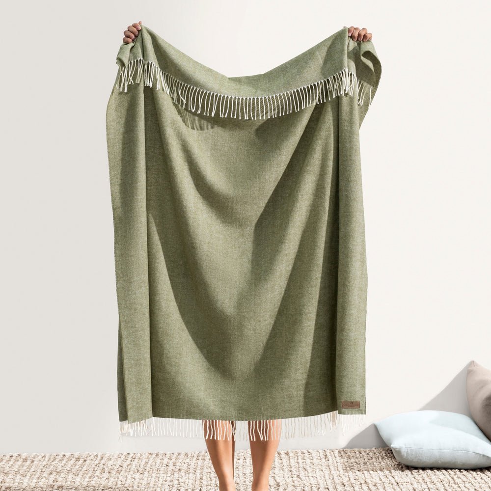 Italian Herringbone Thyme Throw by Lands Downunder - Holding throw with fringe shown