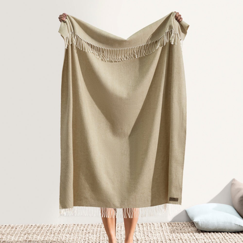 Italian Herringbone White Truffle Throw by Lands Downunder - Holding throw up with fringe shown