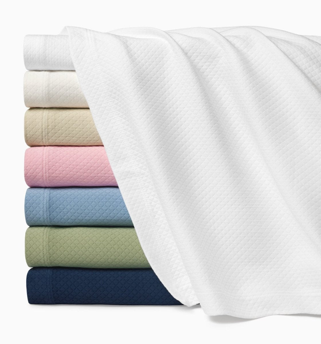 Stack of Sferra Matelasse Coverlets with Rombo Carnation Pink shown in the Middle