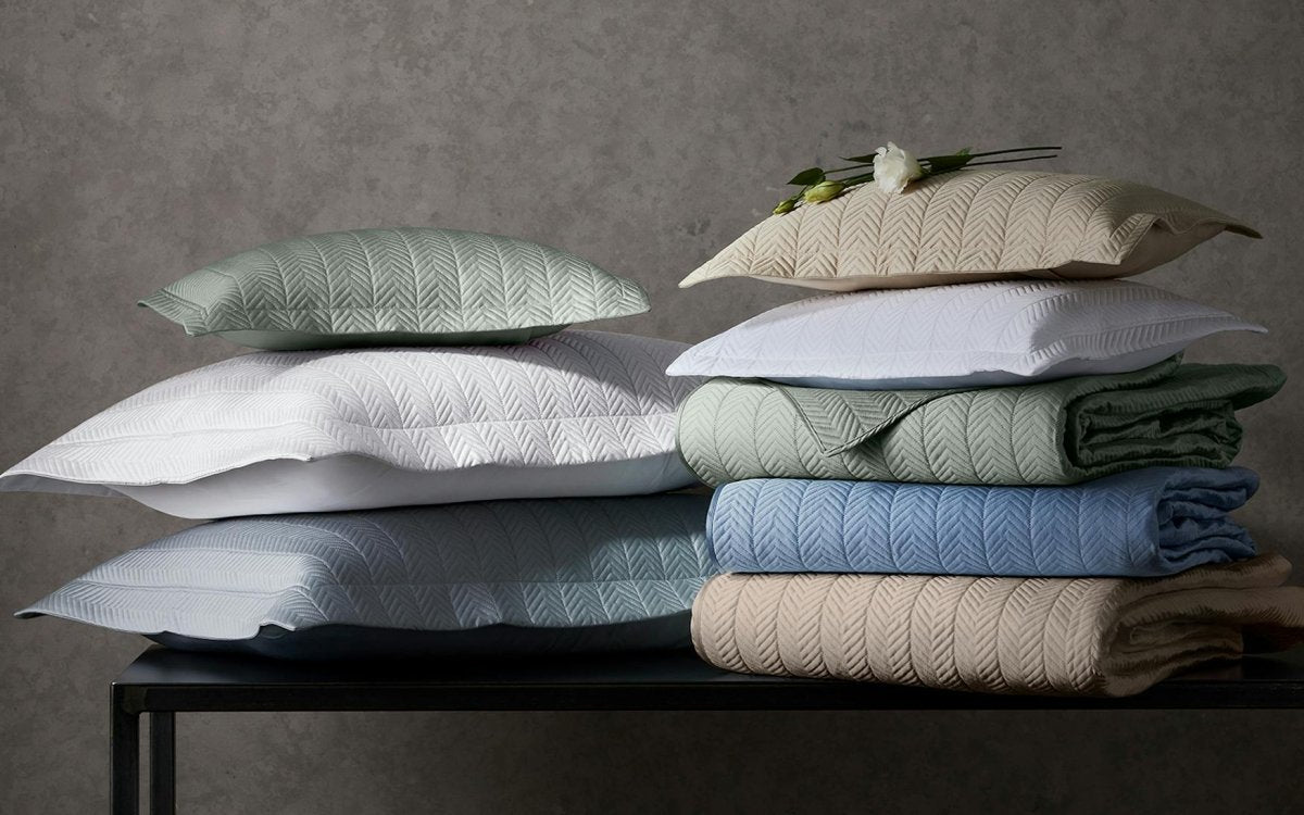 Matouk Netto Quilts & Shams Stacked on Table at Fig Linens and Home