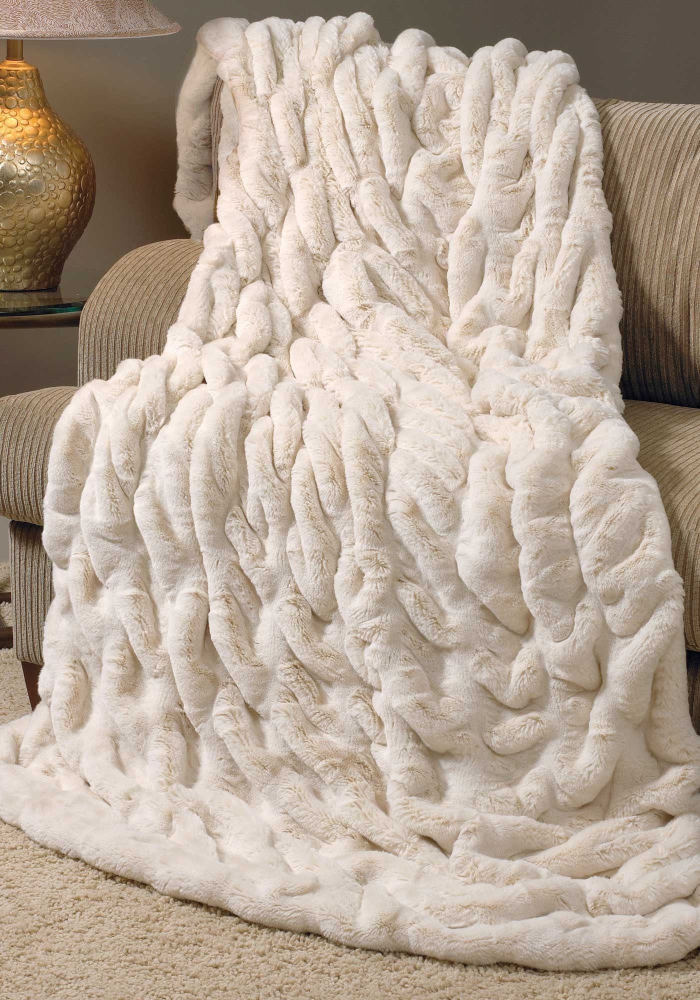 Ivory faux fur throw blanket on chaise
