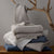 Kiran Towels folded on a chair - Matouk Bath with Waffle Weave and Fringe - Fig Linens and Home