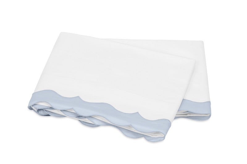 Matouk Lorelei Bedding in Blue - Milano Percale with Hazy Blue Scallop - Flat Sheet Shown Here. Also Available in Matouk Duvet Cover, Matouk Pillowcase and Matouk Pillow Sham. Fitted Sheet is Solid White Milano Percale. Available at Fig Linens and Home