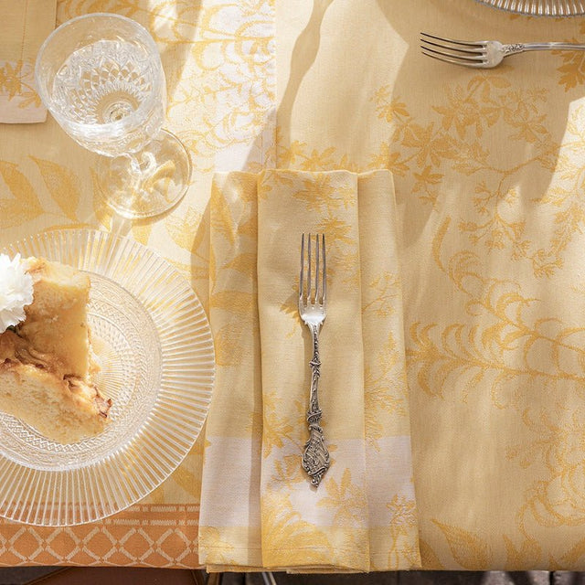 Jardin d'eden yellow napkin by le jacquard français - shown on table