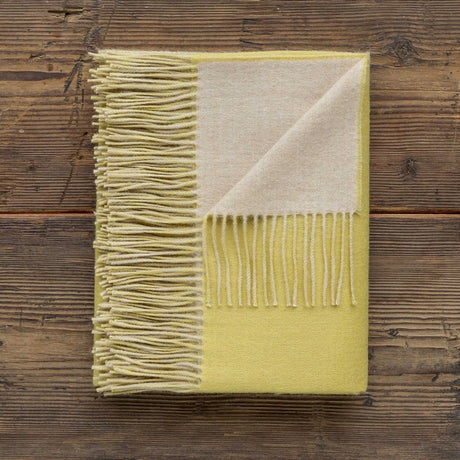 Reversible Throw French Yellow and Beige by Alicia Adams Alpaca shown on Wood