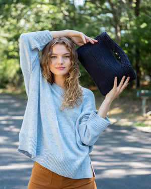 Mer Sea Village Clutch in Navy | Mersea Hand-held Bag - Model holding with 2 hands to show texture 2