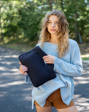 Mer Sea Village Clutch in Navy | Mersea Hand-held Bag - Model holding with 2 hands to show texture 1